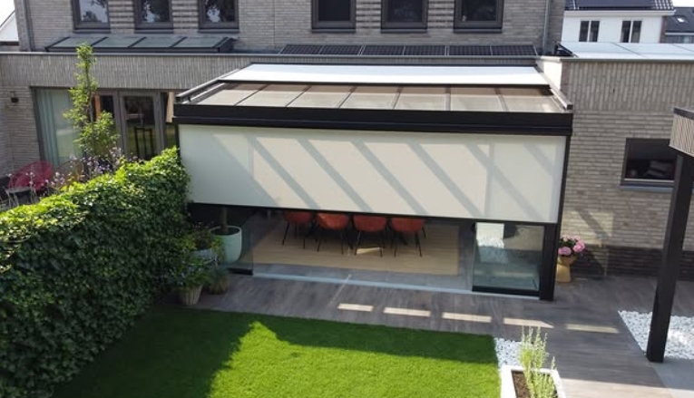 Moderne Terrasse mit Markise, angrenzendem Sitzbereich und gepflegtem Rasen.